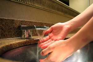 洗手池里的流水把人的手压在下面