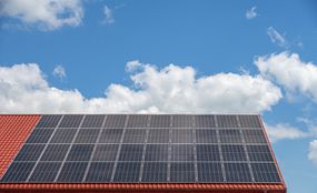 The roof of the house with solar panels against the sky.