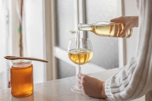 穿毛衣的人把蜂蜜酒倒进酒杯