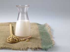 大豆浆的特写与大豆对白色背景的粗麻布