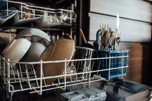 碗和餐具在洗碗机底部的架子上