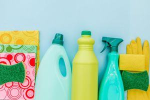 一排清洁用品，包括海绵、三个瓶子和一只黄色橡胶手套