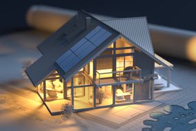 Solar panels on model house with architectural drawing