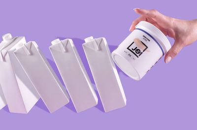 A jar of JOI almond nut base knocking over milk cartons.“width=
