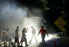 Pedestrians walk through a cloud of dust and diesel exhaust from a transit bus near Yosemite Village, June 16, 2000 in Yosemite National Park, California.