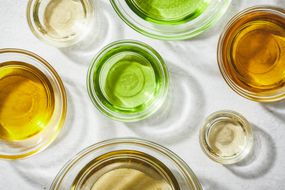 various kinds of oils (castor, olive, almond, coconut) in glass bowls with light reflecting