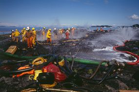 Teams of firefighters cleaning the Alaskan coast following the Exxon Valdez oil spill.